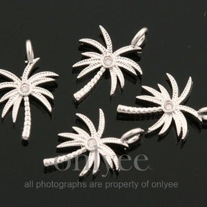 May include: Five silver palm tree charms with clear rhinestone accents. Each charm has a loop for attaching to a necklace or bracelet.