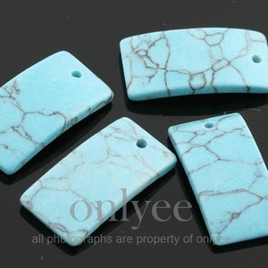 May include: Four turquoise blue rectangular pendant charms with a hole at the top. The charms have a marbled pattern with black veins.