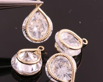 May include: Four gold-tone teardrop-shaped pendants with clear faceted crystals. Each pendant has a gold-tone bail.