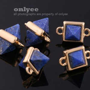 May include: Five gold-toned metal connector charms with blue lapis lazuli pyramid-shaped stones. Two charms feature a square stone with a pyramid top, and three charms feature a pyramid stone with a gold bar across the middle.