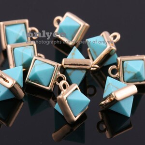 May include: A group of turquoise blue pyramid-shaped charms with gold metal accents. The charms have a gold loop at the top for attaching to jewelry.