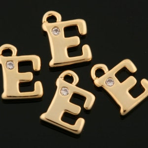Puede incluir: Cuatro abalorios de la letra E en tono dorado con detalles de cristal transparente. Cada abalorio tiene un bucle para sujetarlo a un collar, pulsera u otra joya.