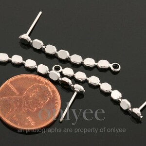 May include: Three silver earring findings with a chain of small, round, silver beads. The findings have a loop at the top and a post at the bottom.