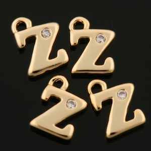 Puede incluir: Cuatro abalorios de metal dorado en forma de letra Z con un acento de cristal transparente. Cada abalorio tiene un bucle para sujetarlo a un collar, pulsera u otra joya.