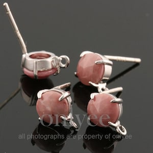 Könnte beinhalten: Vier silberne Ohrringfassungen mit rosafarbenen Edelstein-Cabochons. Jede Fassung hat einen Stift und eine Öse zum Anbringen eines Anhängers.