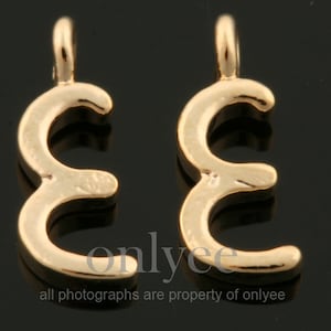 Puede incluir: Dos abalorios de metal de color dorado en forma de número tres. Los abalorios tienen un bucle en la parte superior para sujetarlos a un collar o pulsera.