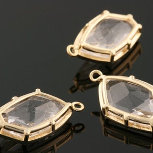 Puede incluir: Tres colgantes de metal dorado con piedras de cristal facetadas transparentes. Cada colgante tiene un bucle en la parte superior para sujetarlo a una cadena o cordón.