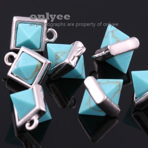 May include: Six turquoise pyramid-shaped charms with silver metal accents. The charms have a hole at the top for attaching to jewelry.
