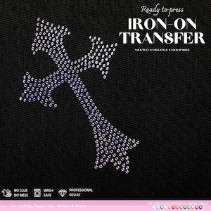 Puede incluir: Una transferencia termoadhesiva con forma de cruz compuesta por pequeños diamantes de imitación iridiscentes y brillantes sobre un fondo de tela negra. El texto dice Ready to press IRON-ON TRANSFER YOUR TEXT + YOUR STYLE + YOUR SPARKLE.
