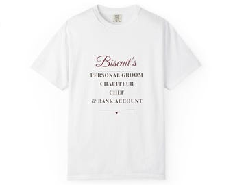 Può includere: Una t-shirt bianca a maniche corte con il testo bordeaux e nero: Biscuit's PERSONAL GROOM CHAUFFEUR CHEF & BANK ACCOUNT, con un piccolo cuore bordeaux centrato sotto il testo. La maglietta presenta un girocollo e una vestibilità standard.