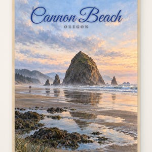 May include: A framed wall art print featuring a scenic landscape of Cannon Beach, Oregon, with Haystack Rock rising from the shoreline. The image displays a sunset sky with soft clouds, wet sand reflecting the light, and rocky tide pools.