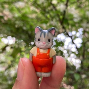 May include: A white ceramic mug with a colorful floral design. The mug features a handle and a wide opening. The flowers are in shades of pink, purple, and yellow. The mug is likely for beverages.