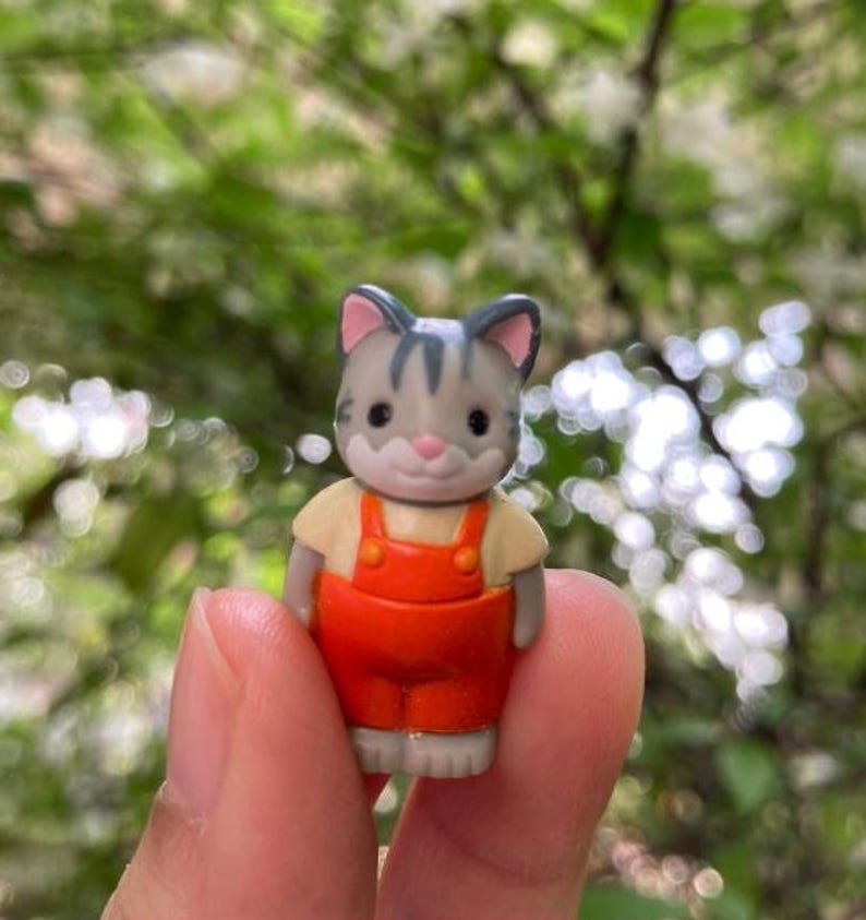 May include: A white ceramic mug with a colorful floral design. The mug features a handle and a wide opening. The flowers are in shades of pink, purple, and yellow. The mug is likely for beverages.