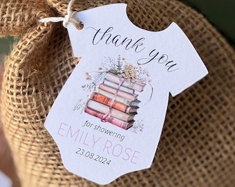 May include: A white thank you tag shaped like a onesie with a stack of books, flowers, and the text "Thank you for showering Emily Rose 23.08.2024".