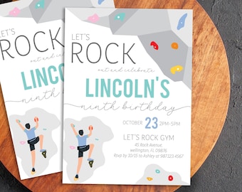 May include: Two white invitation cards with a climbing theme. The cards read "Let's Rock" and "Lincoln's ninth birthday" with a graphic of a person climbing. The date is October 23rd.