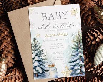 Op de afbeelding: Een baby shower uitnodiging met een winterthema. De uitnodiging heeft een aquarel illustratie van twee besneeuwde dennenbomen, een babyfles en sneeuwvlokken. De tekst op de uitnodiging luidt "Baby it's cold outside" en "Aliya James".