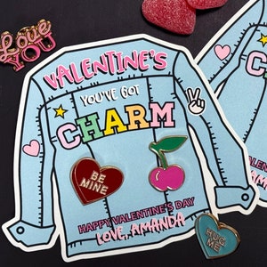 May include: Two Valentine's Day cards featuring a denim jacket design with the text "You've got charm" and a heart, cherry, and heart pins. The cards include the text "Happy Valentine's Day, Love, Amanda".