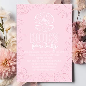May include: Pink baby shower invitation with seashell illustrations and the text "BOOKS for baby." The invitation includes a request for guests to bring a signed storybook instead of a card. Floral accents frame the invitation.