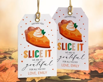 May include: Two gift tags with a pumpkin pie slice illustration. The tags read "SLICE IT, we are so grateful, for all you do! Love, Emily." The tags are white with a brown string.