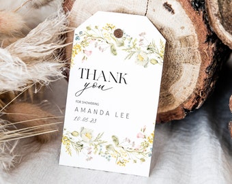Puede incluir: Una etiqueta de agradecimiento blanca con un diseño de corona floral. El texto dice "Gracias" en fuente de letra cursiva negra y "Por la ducha Amanda Lee 10.05.23" en fuente sans-serif negra.