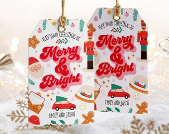 Könnte beinhalten: Zwei rechteckige weiße Geschenkanhänger mit goldenen Ösen und beigen Bindfäden. Die Anhänger zeigen den roten Schriftzug "MAY YOUR CHRISTMAS BE MERRY & BRIGHT" und "EMILY AND JASON" sowie Illustrationen von Nussknacker, Weihnachtsmann und Auto.
