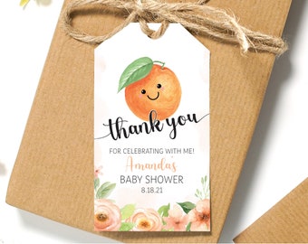 Può includere: Etichetta di ringraziamento per un baby shower arancione con un'illustrazione di arancia sorridente e accenti floreali. L'etichetta dice "Grazie per aver festeggiato con me! Baby Shower di Amanda 8.18.21".