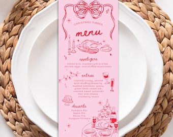 May include: A pink Christmas dinner menu card with red illustrations. The menu includes appetizers, entrees, and desserts. The card is on a white plate, set on a woven placemat.