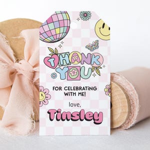 Op de afbeelding: Een roze en witte geruite cadeaulabel met de woorden "THANK YOU" in kleurrijke bubbelletters. Het label bevat illustraties van een discobal, smiley en vlinder. Tekst op het label luidt "FOR CELEBRATING WITH ME! love, Tinsley."