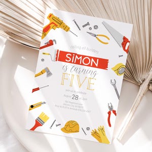 May include: A birthday party invitation for a boy named Simon turning five. The invitation features a red and yellow paint roller with the text "Simon is turning Five" in gold and red lettering. The invitation is decorated with various tools, including a hammer, saw, wrench, and screwdriver.