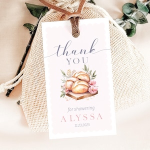 May include: A gift tag with the words "thank you" in script, and "YOU" in block letters. The tag features a watercolour illustration of bread rolls, flowers, and greenery. The text "for showering ALYSSA 11.23.2025" is also on the tag.