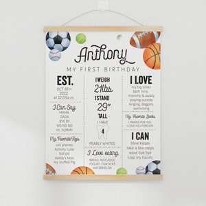 May include: A colorful printable first birthday chart for a boy named Anthony. The chart features a sports theme with illustrations of baseballs, basketballs, soccer balls, and tennis balls. The chart includes information about Anthony's age, weight, height, favorite toys, foods, books, and activities. The text on the chart reads: "Anthony, My First Birthday, Est. Oct 8th 2022 at 12:09 a.m., I Weigh 21 lbs, I Stand 29" Tall, I Have 4 Pearly Whites, I Love My Big Sister, Bath Time, Mommy & Daddy, Playing Outside, Singing, Doggies, Swimming, My Favorite Books: I Prayed For You, I Love You Forever, I Can Blow Kisses, Take A Few Steps, Wave Bye Bye, Clap My Hands, I Can Say: Mama, Dada, Bye Bye, No No No, Hi Yummy, My Favorite Toys: Cell Phones, Activity Cube, Ball Pit, Daddy's Keys, My Stuffed Pig, I Love Eating: Bread, Avocados, Yogurt, Crackers, Watermelon."