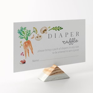 May include: A white card with a watercolor illustration of a carrot, mushrooms, and leaves. The text on the card reads "DIAPER raffle please bring a pack of diapers in any size to be entered to win a prize Name_"