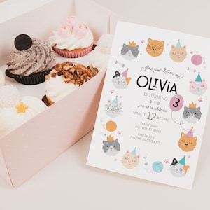 May include: A pink and white birthday invitation with a cat theme. The invitation says "Are you kitten me? Olivia is turning 3. Join us to celebrate March 12 at 2 PM. 37 East Street, Truckville, NJ 07865. RSVP by 10/1. Amanda 897-765-4321."