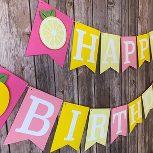 May include: A pink and yellow banner with the words "Happy Birthday" and lemon cutouts.