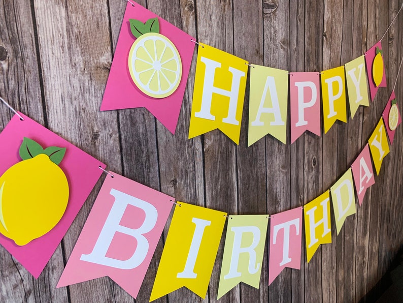 May include: A pink and yellow banner with the words "Happy Birthday" and lemon cutouts.