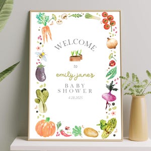May include: A white baby shower invitation with a green, red, and yellow watercolor border of vegetables and a bee. The text reads "Welcome to Emily Jane's Baby Shower 4.28.2025".