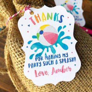 May include: A white thank you tag with a colorful beach ball and blue water splash design. The tag says "Thanks for making my party such a splash! Love, Amber".