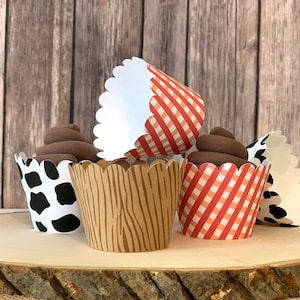 May include: A set of six cupcake liners with different patterns. The liners are white with red and white gingham, brown woodgrain, and black and white cow print.