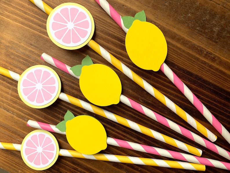 May include: Six yellow and pink paper straws with lemon and grapefruit designs. The straws are striped with pink and yellow.