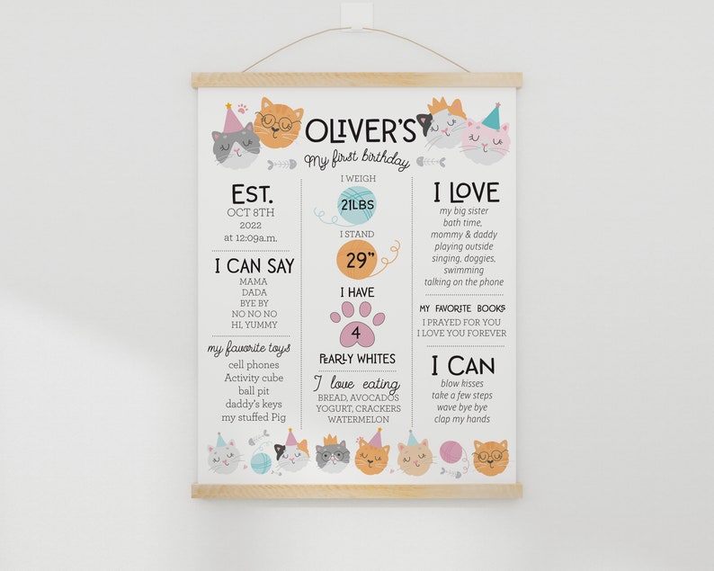 May include: A colorful printable poster with a cat theme celebrating a child's first birthday. The poster includes the child's name, Oliver, and details about their first year, including their weight, height, favorite foods, and things they can do. The poster is decorated with cute cartoon cats.