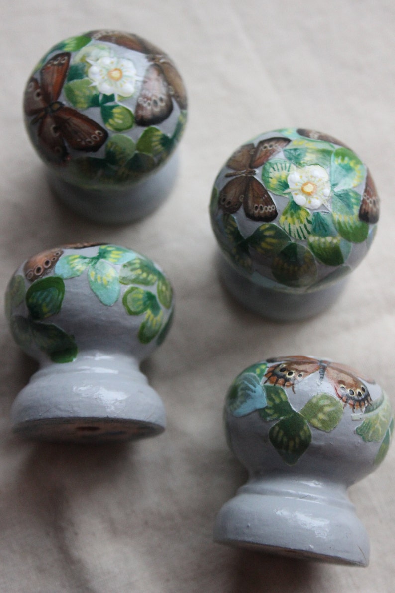 K&ouml;nnte beinhalten: Vier Keramikkn&ouml;pfe mit einer hellblauen Basis und einem wei&szlig;en, gr&uuml;nen und braunen Schmetterlingsdesign.