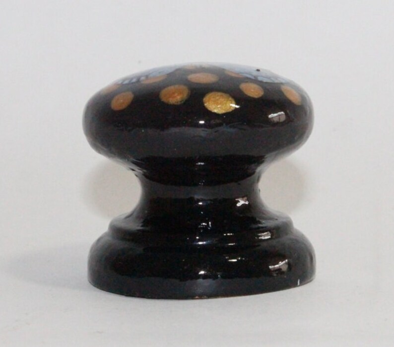 Pode incluir: Bot&atilde;o de cer&acirc;mica preto com bolinhas douradas e azuis.