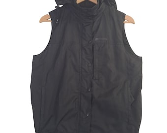 May include: A solid black sleeveless vest featuring a detachable hood, a high collar, and a front placket with snap button closures. The garment includes a vertical zippered chest pocket and an adjustable drawstring hem for a secure fit.