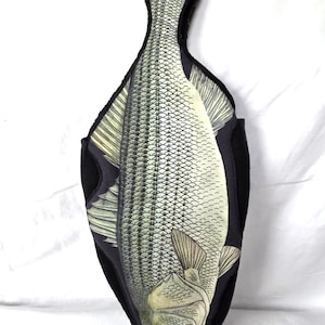 May include: A decorative fish-shaped pillow with a detailed illustration of a fish in shades of gray and cream. The pillow has a black border and is designed to resemble a mounted fish.