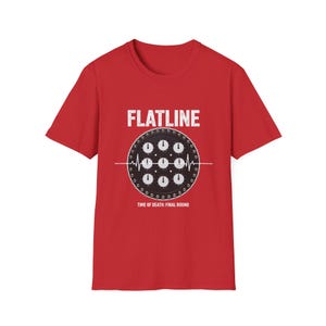 May include: A red short-sleeved t-shirt featuring a graphic of a black circular clock face with nine smaller dials and a white heartbeat line. The text "FLATLINE" appears above the graphic, and "TIME OF DEATH: FINAL ROUND" is printed below it.