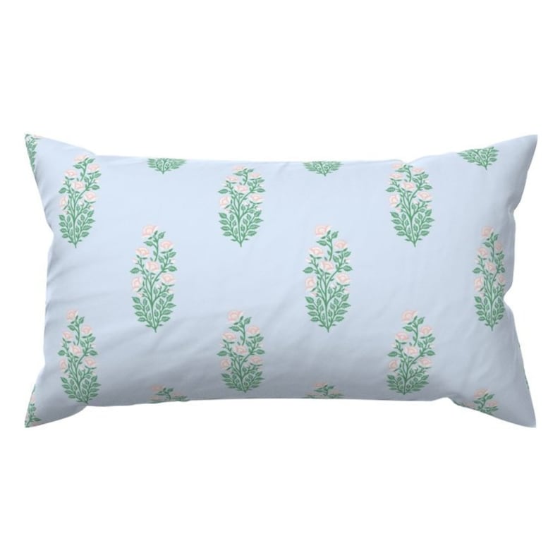 May include: A light blue pillow with a floral pattern of pink flowers and green leaves.