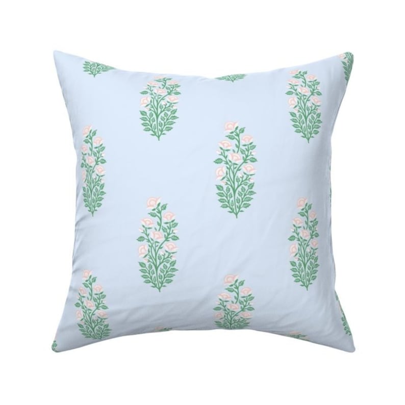 May include: A light blue square pillow with a repeating pattern of pink and green floral designs.