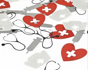 Può includere: Una collezione di coriandoli di carta a tema medico con cuori rossi con ritagli a croce bianca, cuffiette da infermiere bianche, siringhe argentate e sagome di stetoscopi neri sparsi su una superficie bianca.