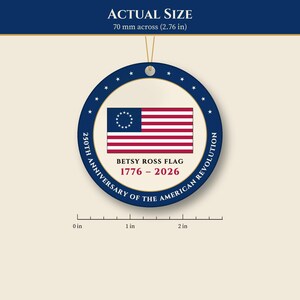 May include: A round ornament featuring the Betsy Ross flag with thirteen stars in a circle. Text reads: BETSY ROSS FLAG 1776 - 2026 250TH ANNIVERSARY OF THE AMERICAN REVOLUTION. A ruler shows a diameter of 2.76 inches.