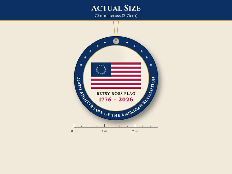 May include: A round ornament featuring the Betsy Ross flag with thirteen stars in a circle. Text reads: BETSY ROSS FLAG 1776 - 2026 250TH ANNIVERSARY OF THE AMERICAN REVOLUTION. A ruler shows a diameter of 2.76 inches.